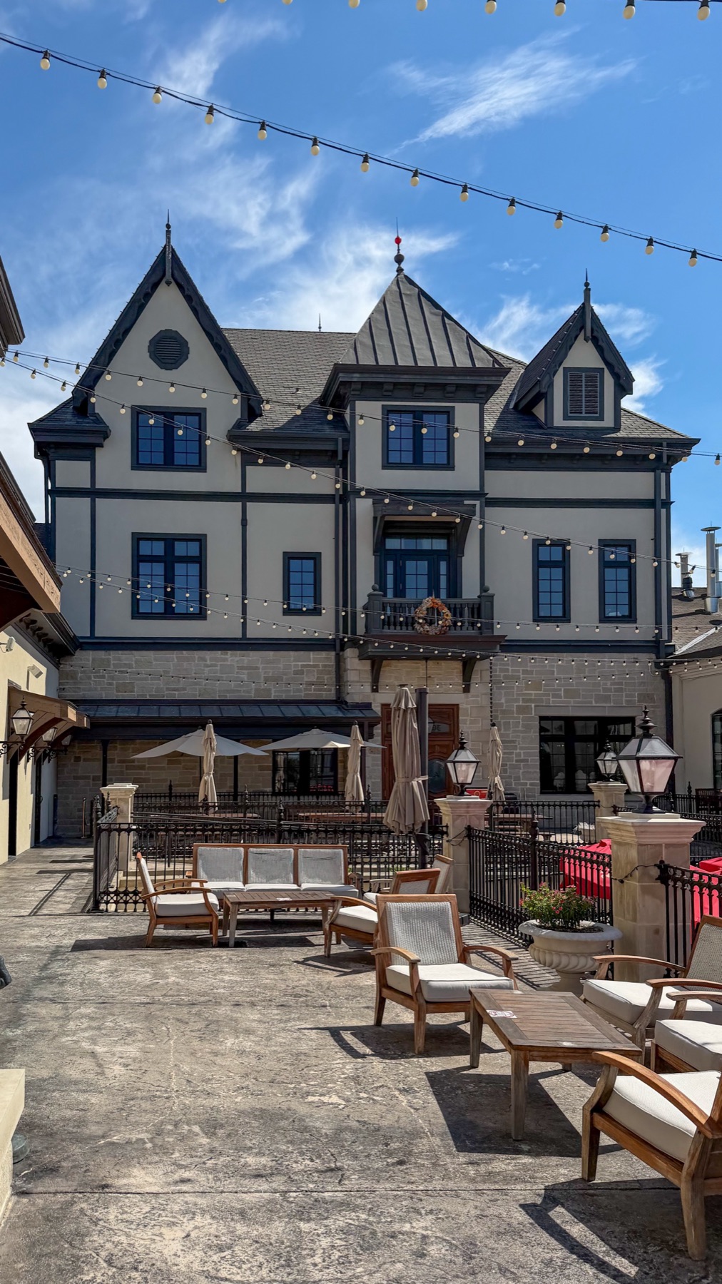The exterior of Altstadt Brewery with string lights and patio furniture