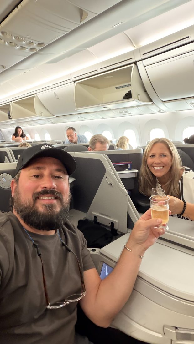 In lie-flat seats with a drink, heading west