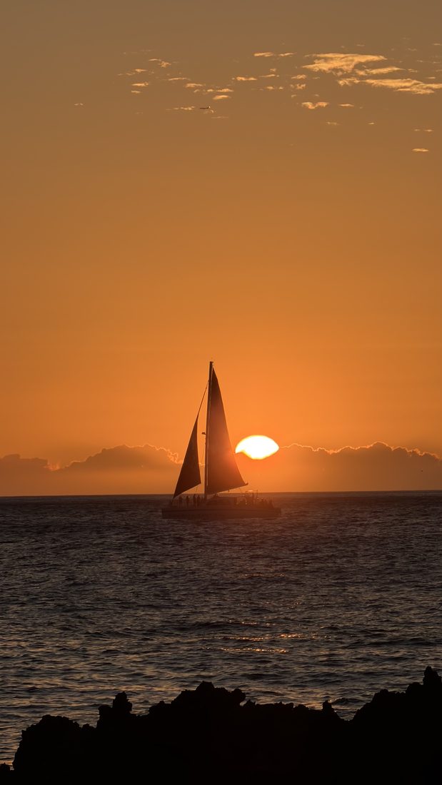 A sailboat against the setting sun