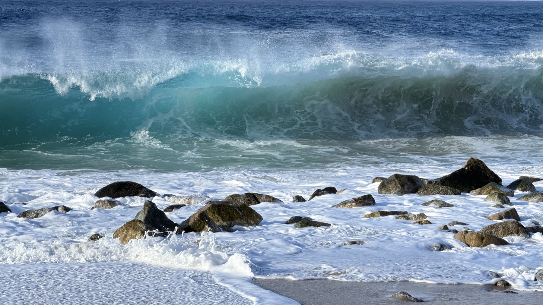 A wave barrelling over rocks