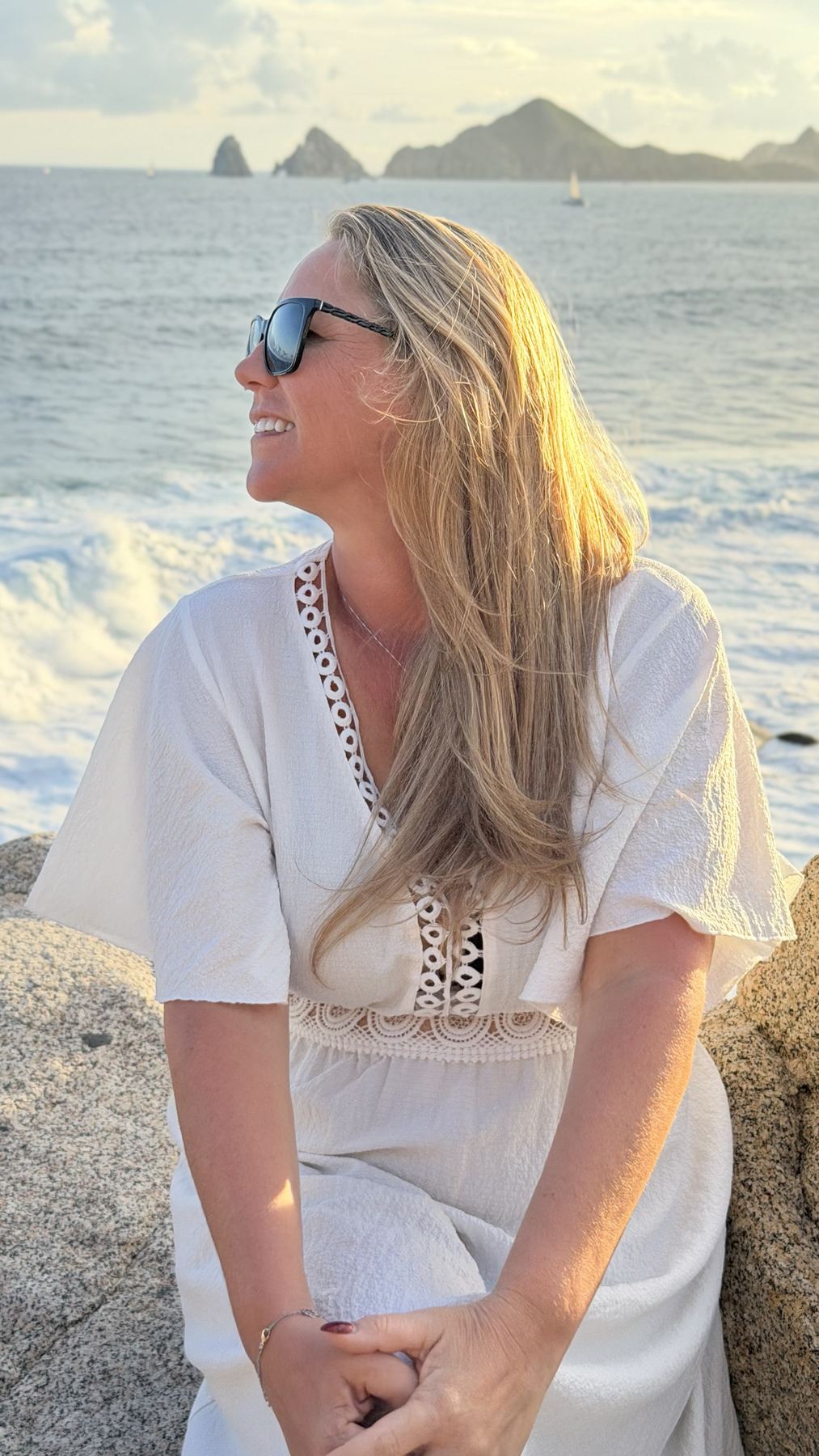 Amber on the rocks at golden hour with Land's End behind her