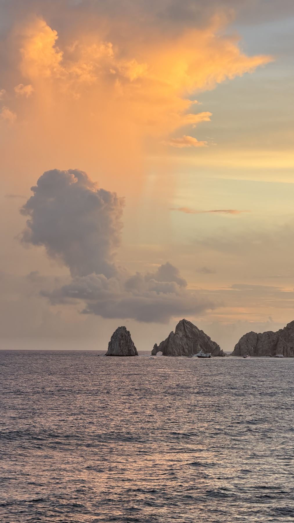 El Arco at Land's End under an orange sunset sky