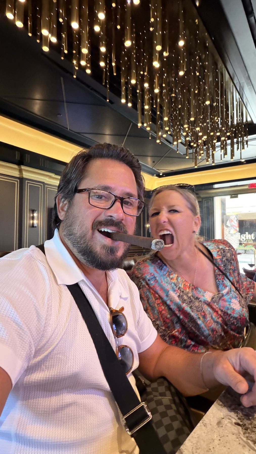 Matt and Amber laughing at the cigar lounge, one cigar between them