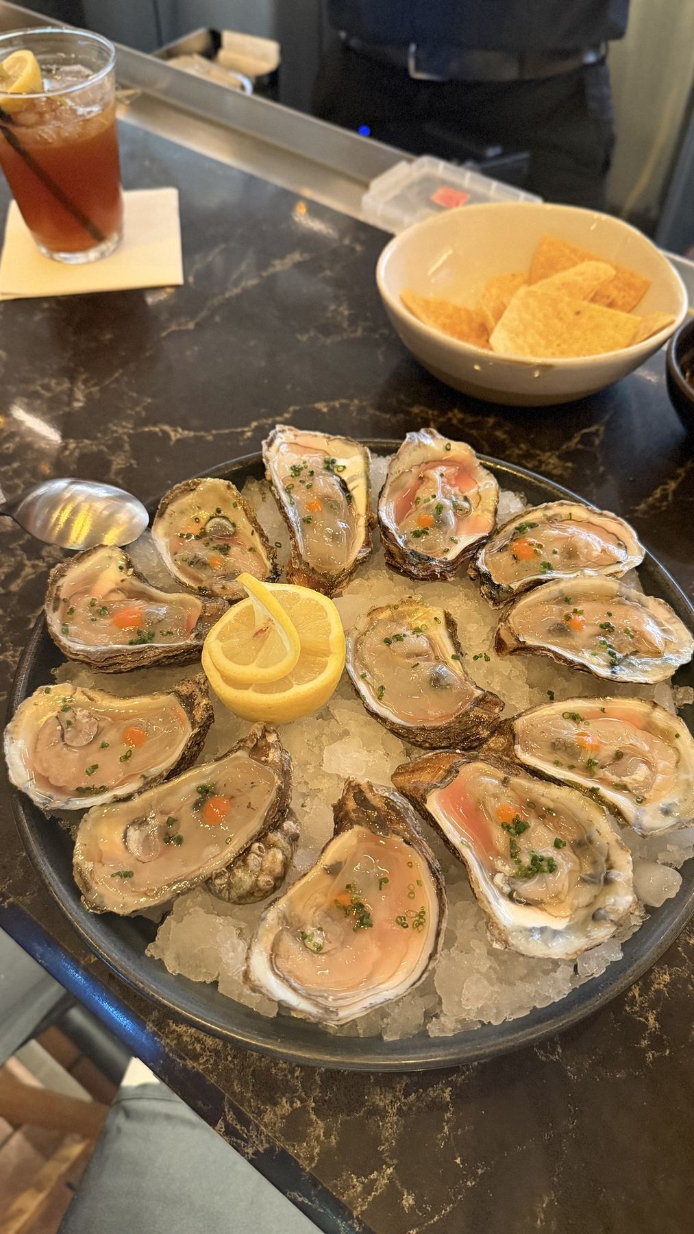 A platter of oysters on crushed ice with lemon