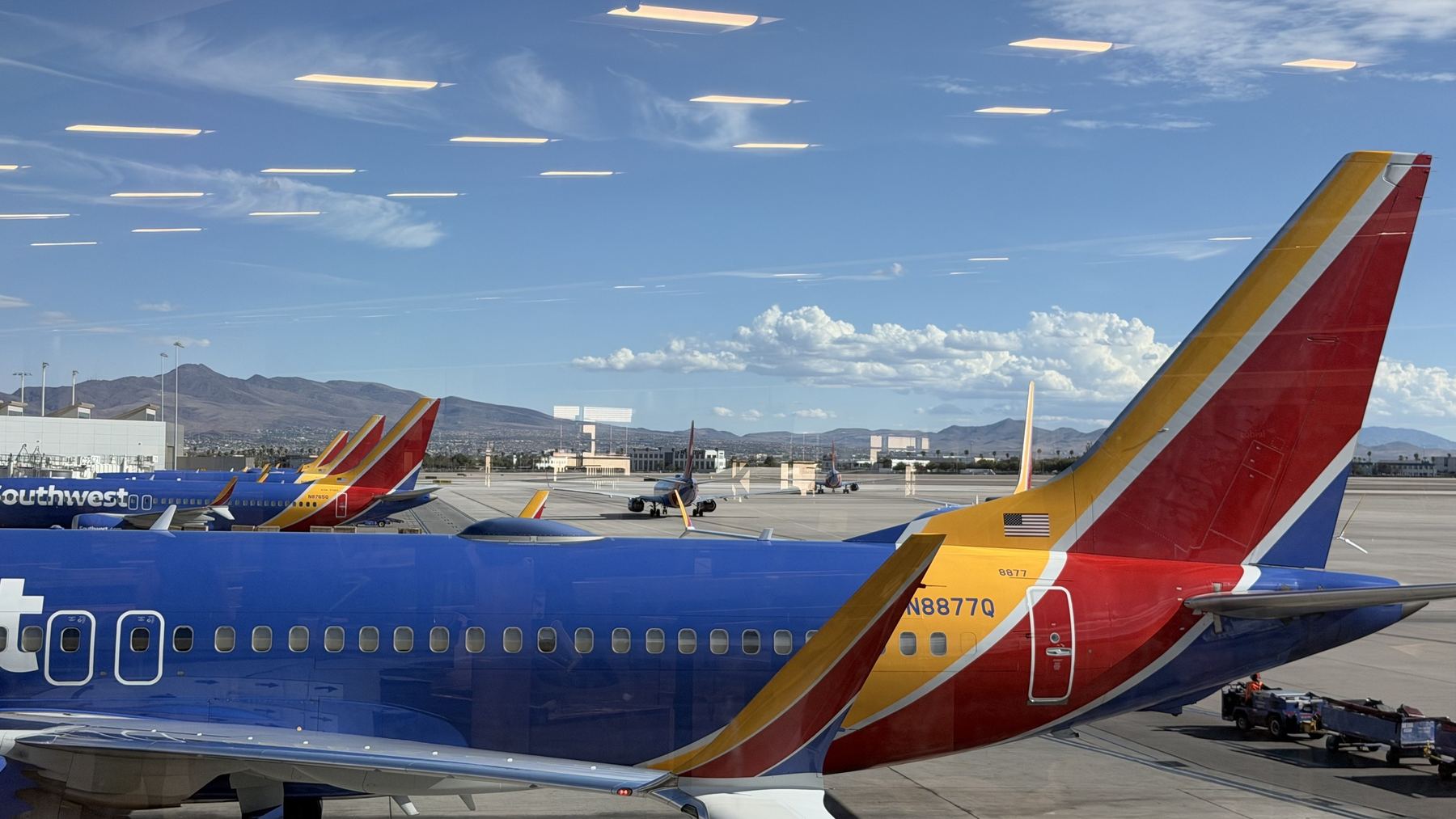 A row of Southwest 737 tails at the gate with desert mountains behind